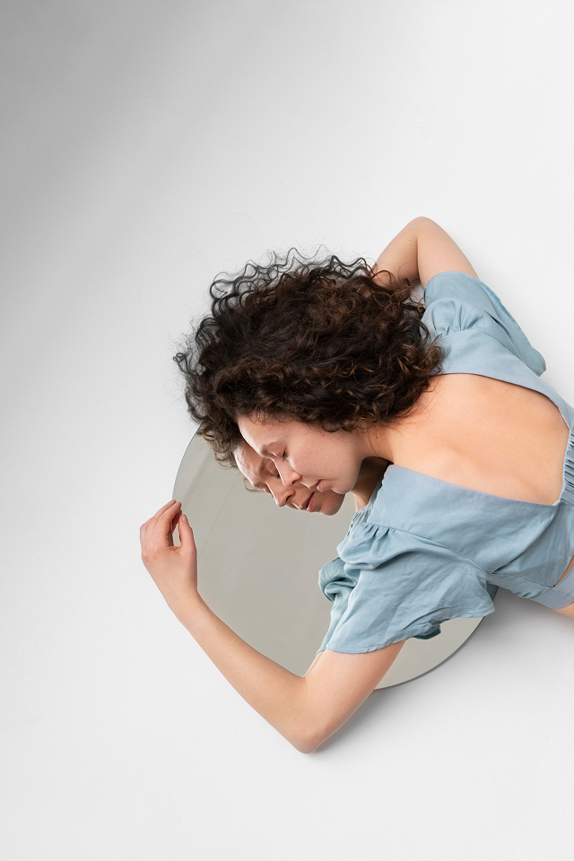 mulher abraça em paz o espelho com o seu reflexo, mostrando autoconfiança